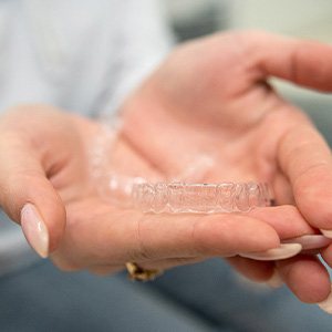 Closeup of patient holding clear aligner