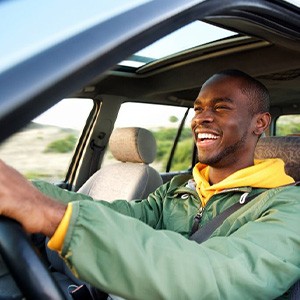 Man smiles while driving