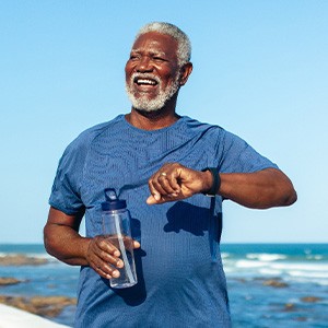 Senior man smiling while walking on beach path