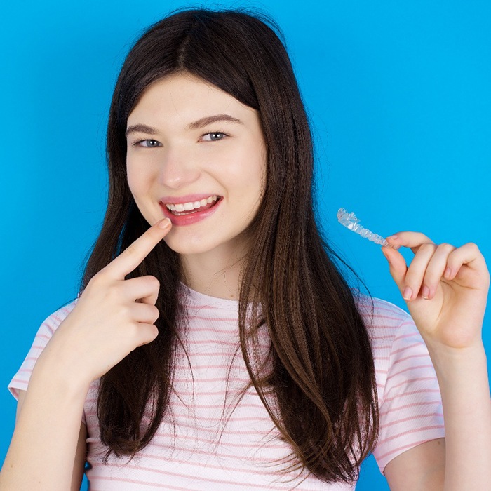 Teenage female holding an Invisalign aligner