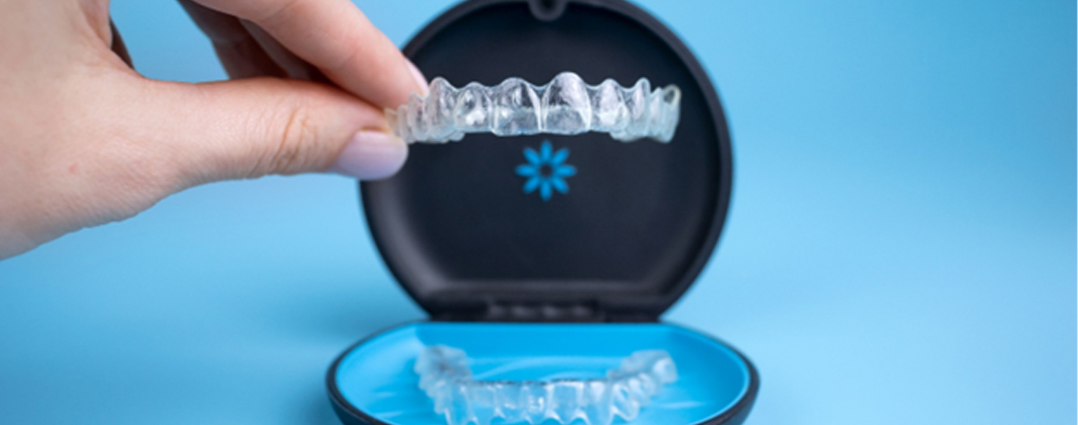 Fingers lifting Invisalign out of carrying case